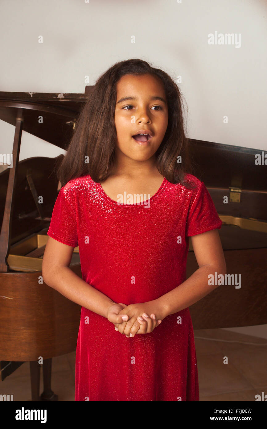 Young African American girl singing at her recital. MR © Myrleen Pearson Stock Photo