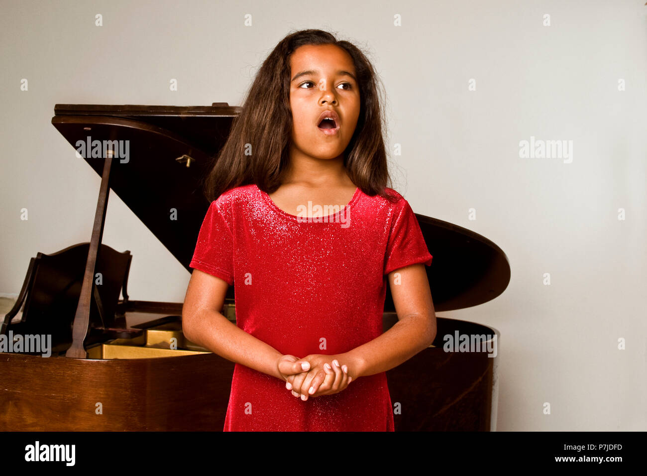 Young African American girl singing at her recital. MR © Myrleen Pearson Stock Photo