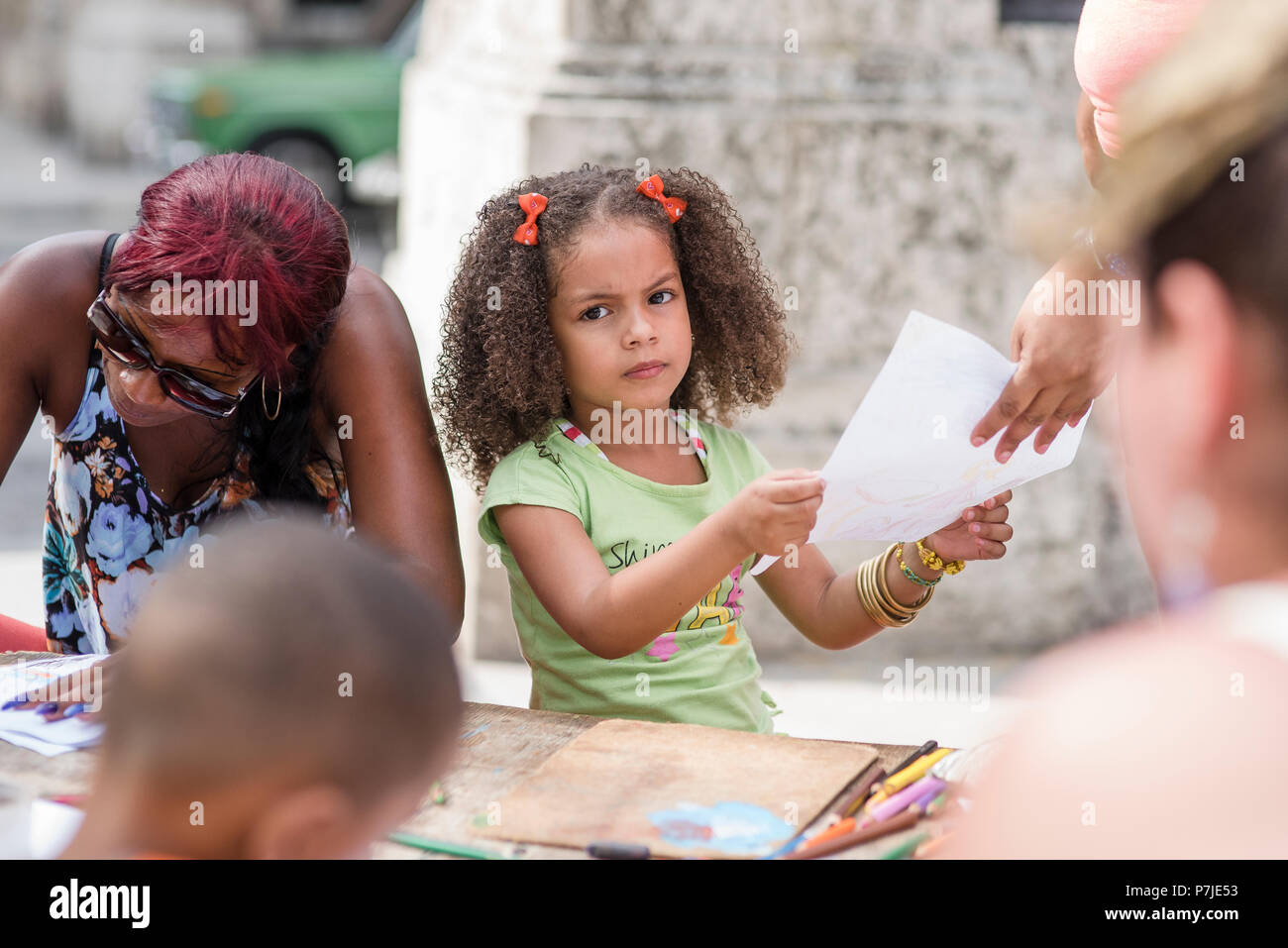 Children draw and color at a craft market while their parents shop. Stock Photo