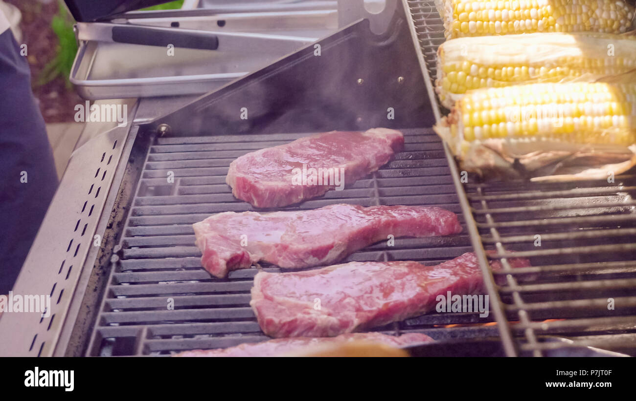Step by step. Raw New York strip steak ready for outdoor grilling Stock