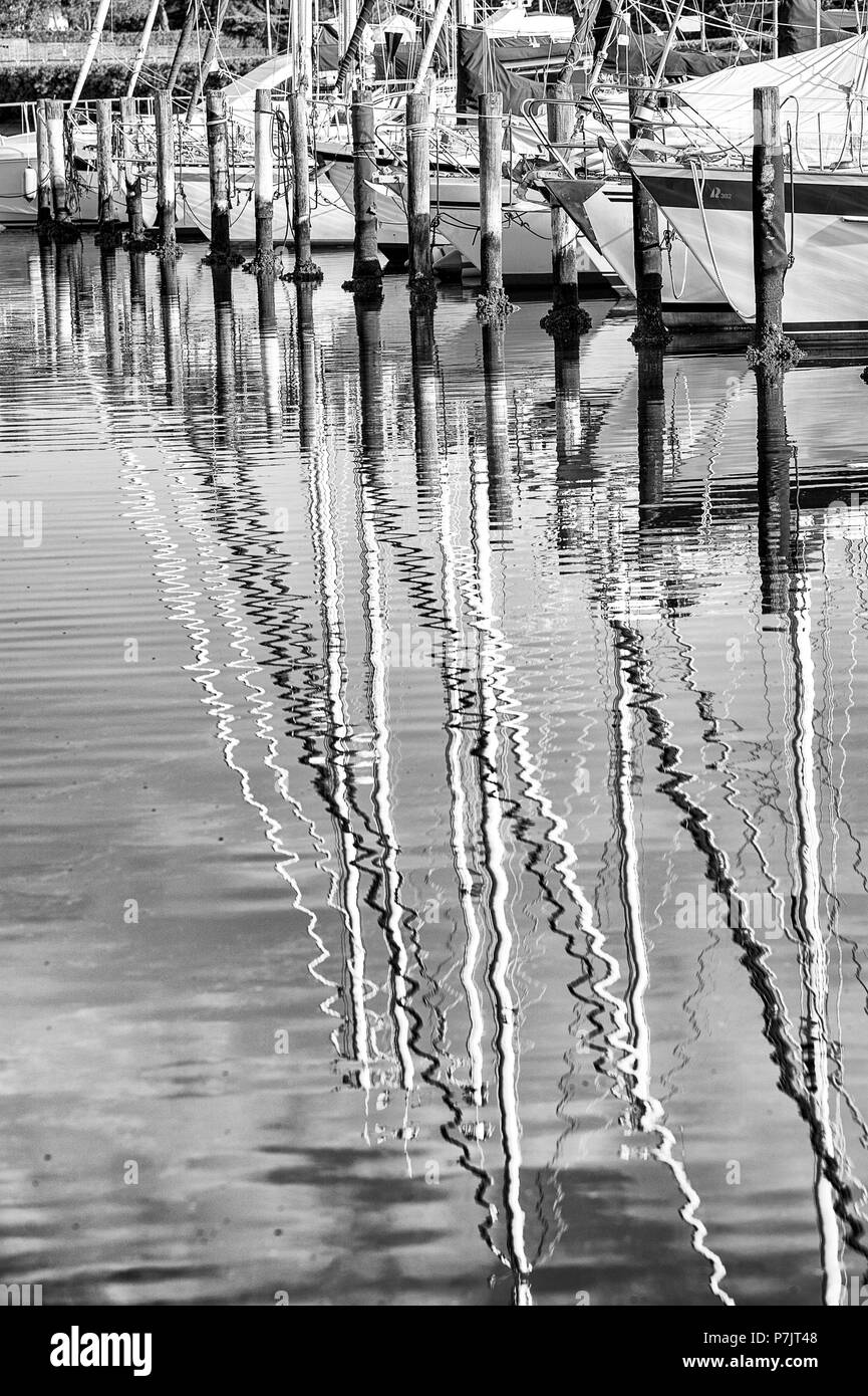 Details in the harbour of Lignano, sailing ships are reflected in the water Stock Photo