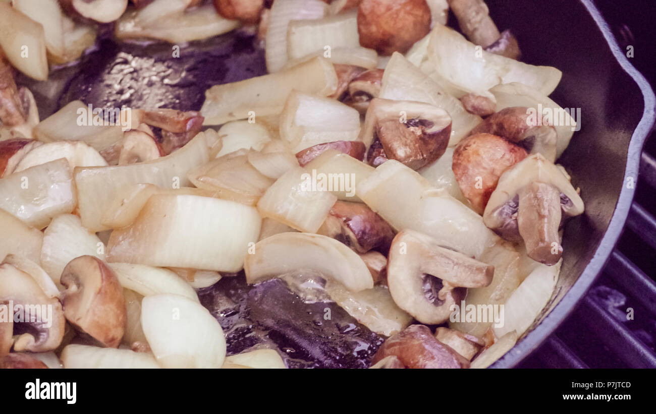 Step by step. Grilled mushrooms and onions in cast iron frying pan on