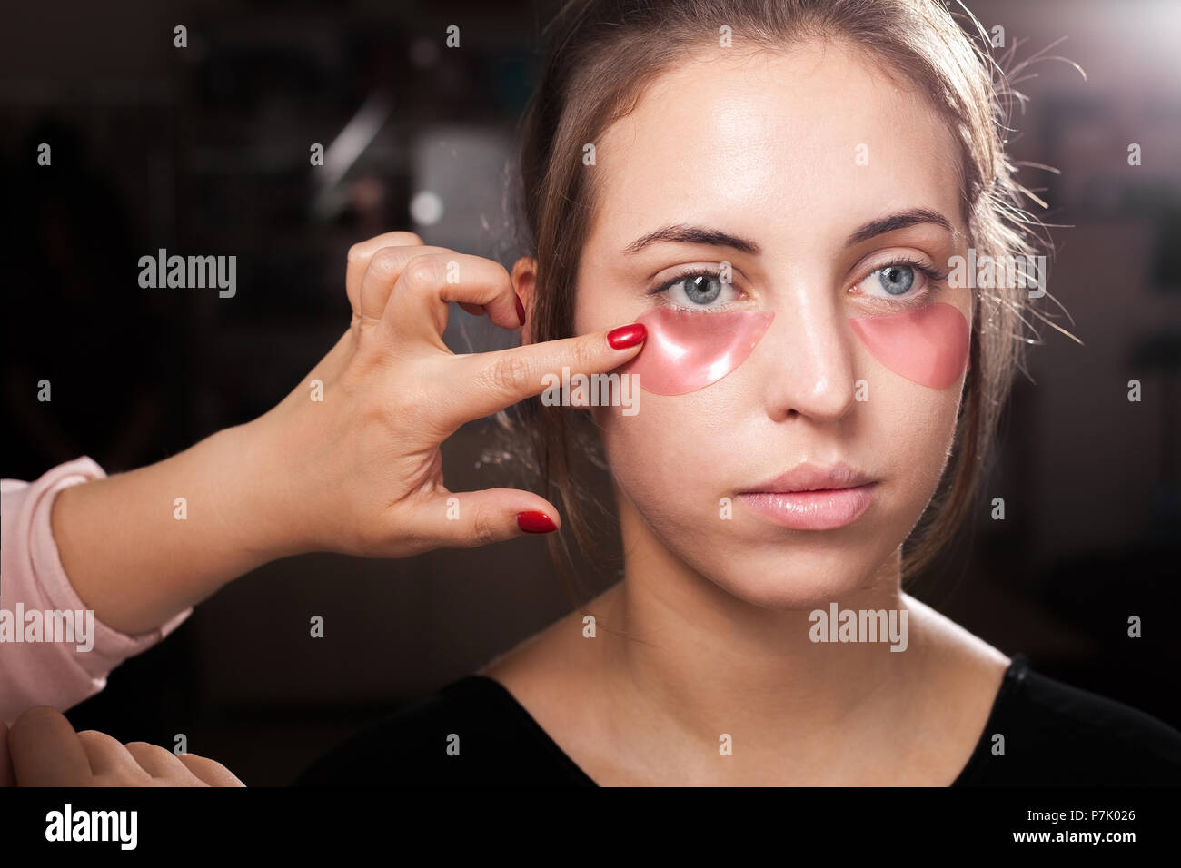 makeup artist applying hydrogel eye patches at a woman Stock Photo Alamy
