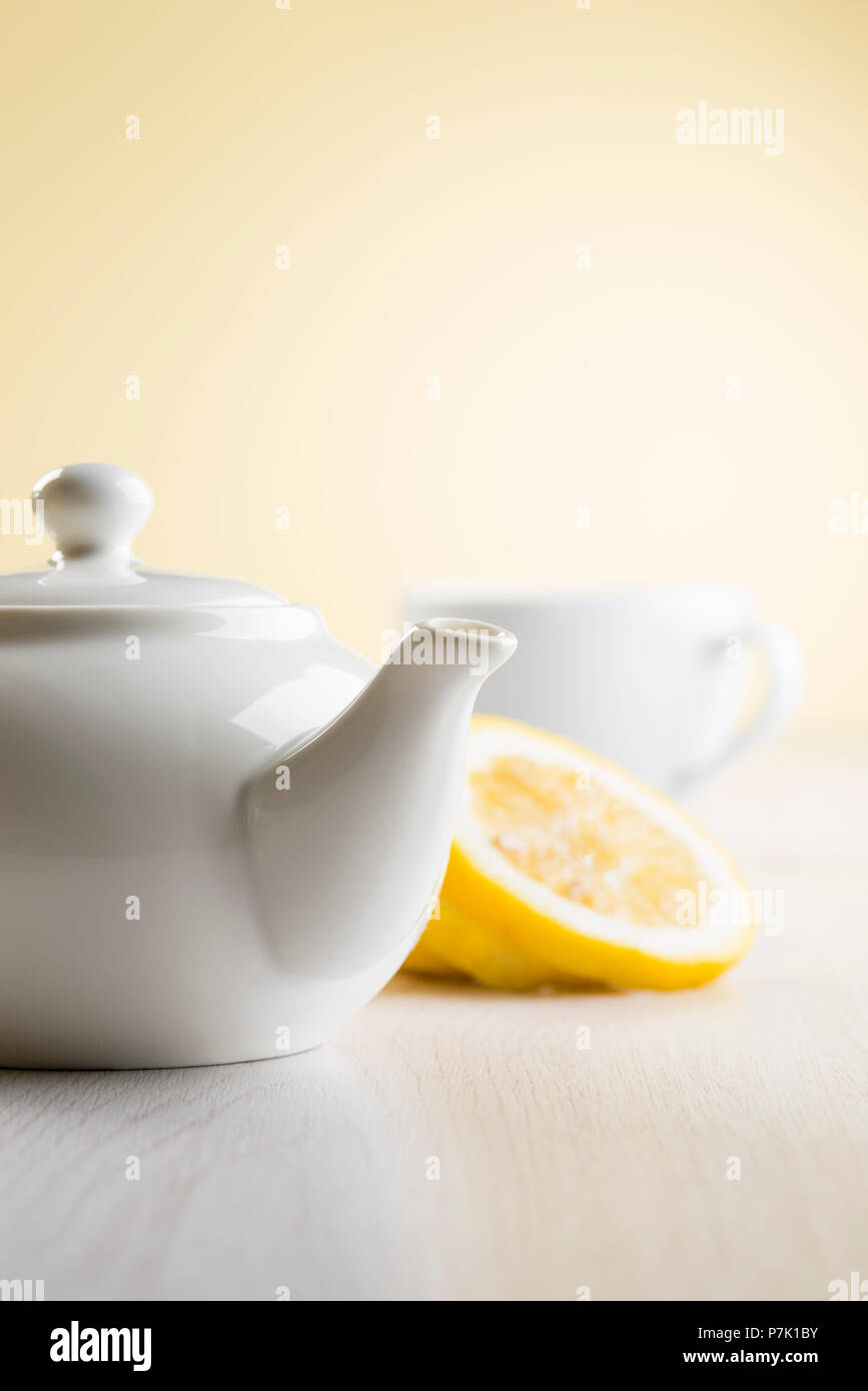 white teapot on table with lemon slices Stock Photo
