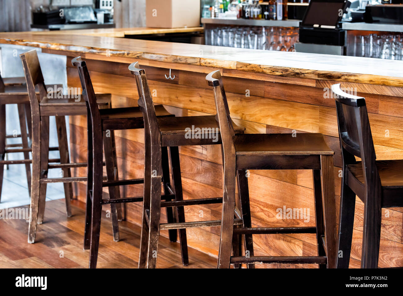 Row of empty wooden vintage bar stools by counter in drink establishment pub  during day pattern closeup, retro wood and nobody Stock Photo - Alamy