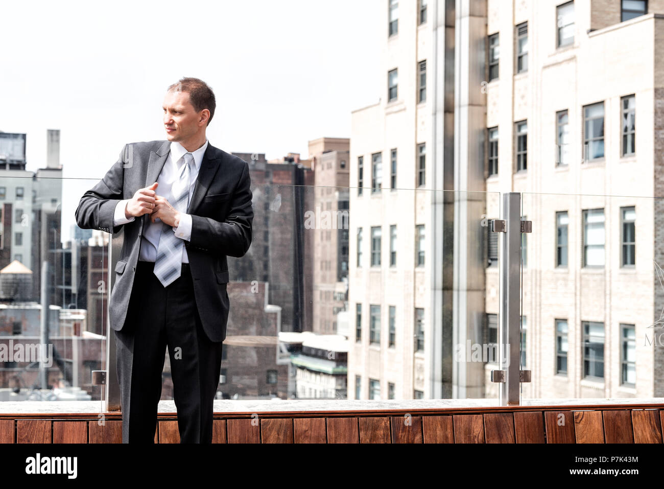 Young serious businessman standing in business suit in New York City ...