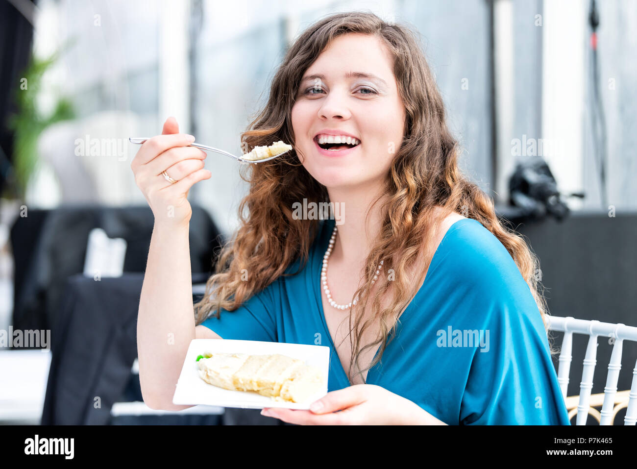 Young elegant smiling happy woman eating cake, open mouth with fork at