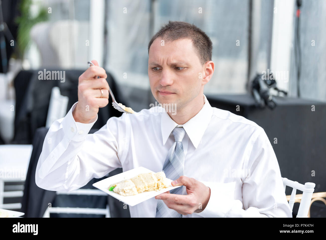 Young Guilty Unsure Man In Business Formal Dress Shirt Eating Cake