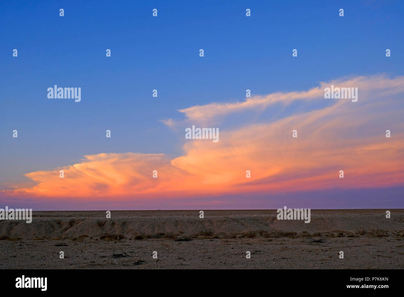 Evening mood after sunset with coloured clouds over a lonely, empty desert landscape in Namibia, Dorob National Park Stock Photo