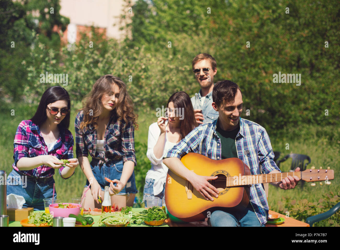 Group of friends having picnic in park Stock Photo - Alamy