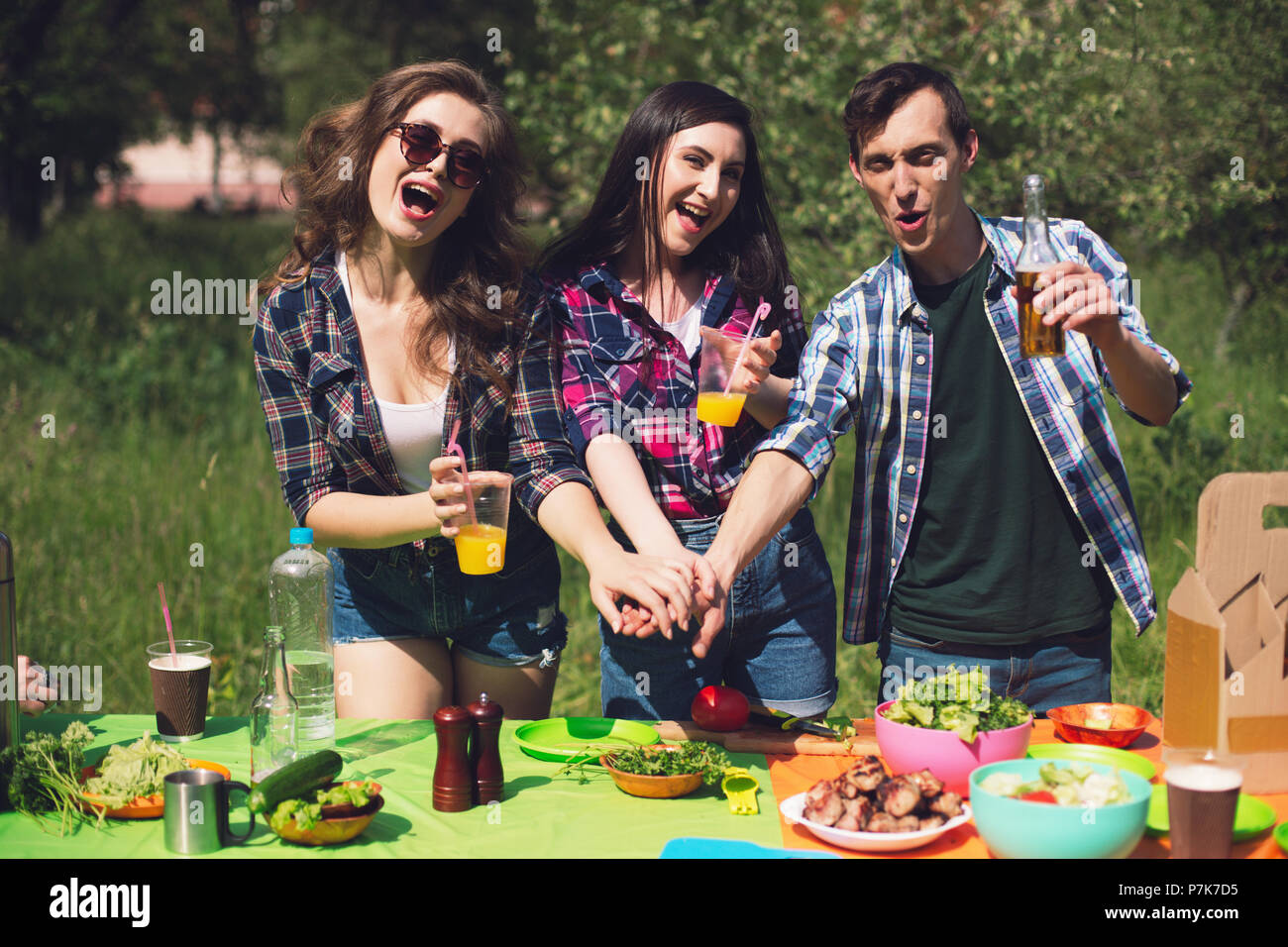 Group of friends having picnic in park Stock Photo - Alamy