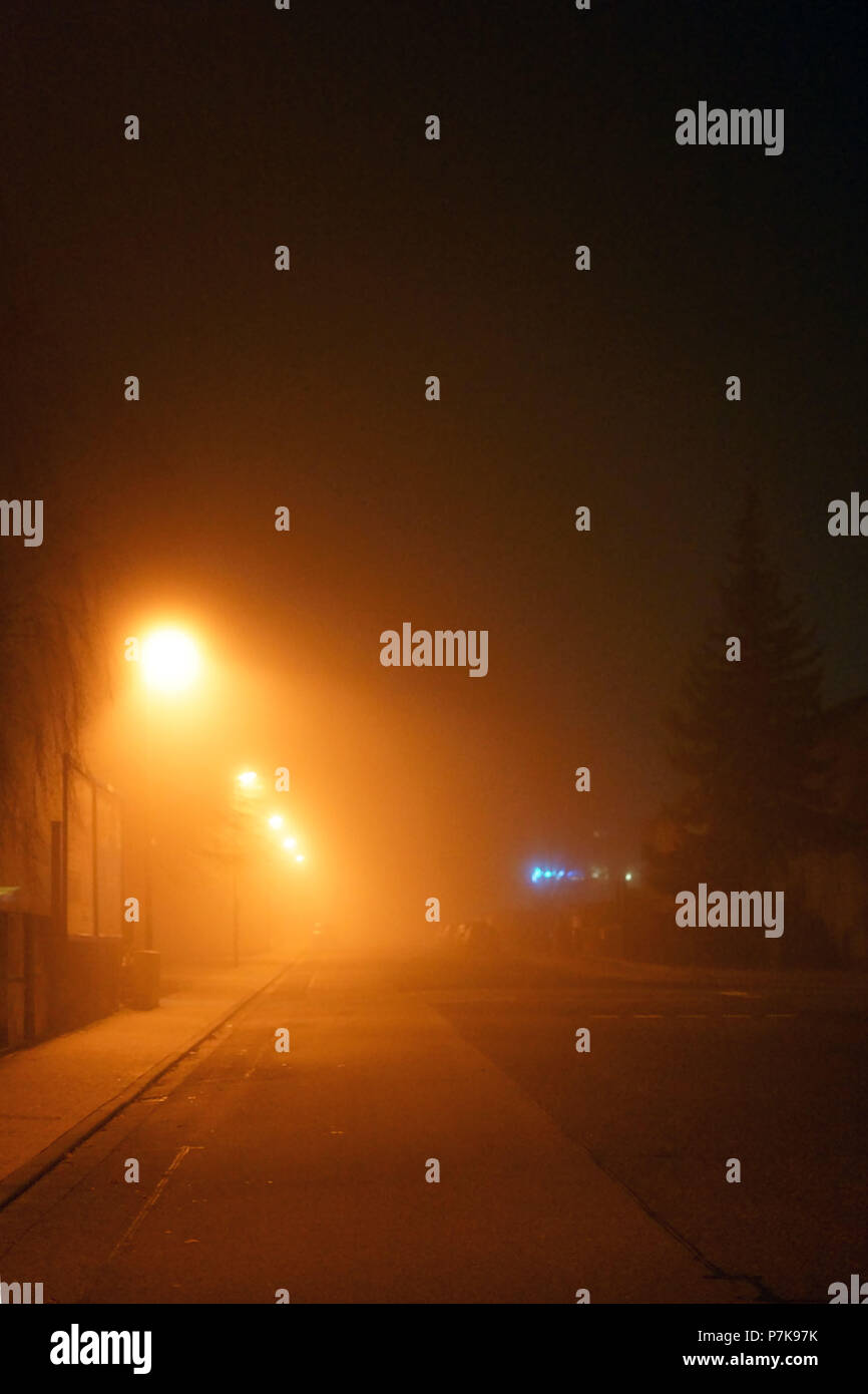 A street with illuminated street lamps at night and in the fog, Stock Photo