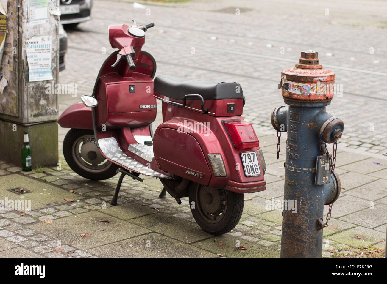 Old Vespa next to a fire hydrant on the roadside Stock Photo