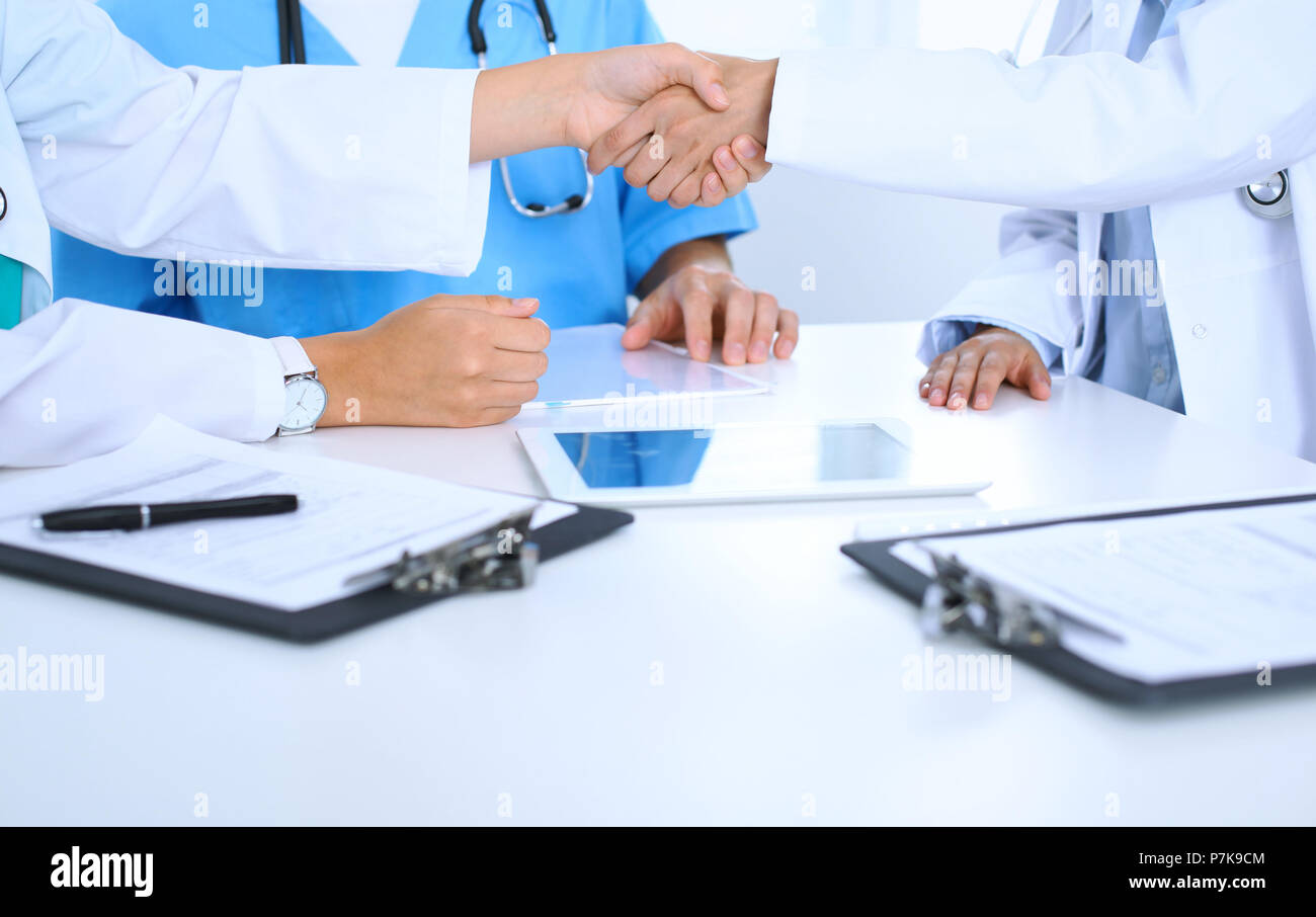 Two Doctor Handshake Two doctors shaking hands to each other at meeting. Teamwork and ...