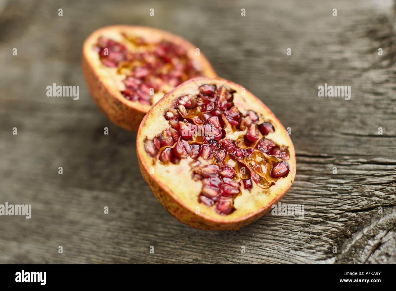Sliced ??pomegranate on wooden table Stock Photo