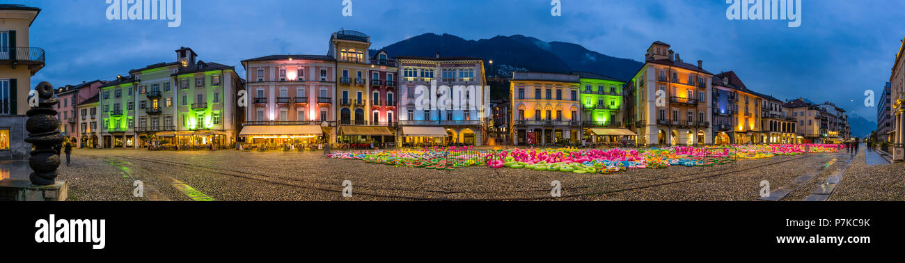 Panorama of the Piazza Grande in Locarno in the evening with art installation of colorful plastic flamingos and other rubber animals Stock Photo