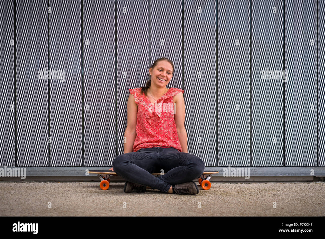 Woman with longboard, 23 years old, portrait, urban environment Stock Photo