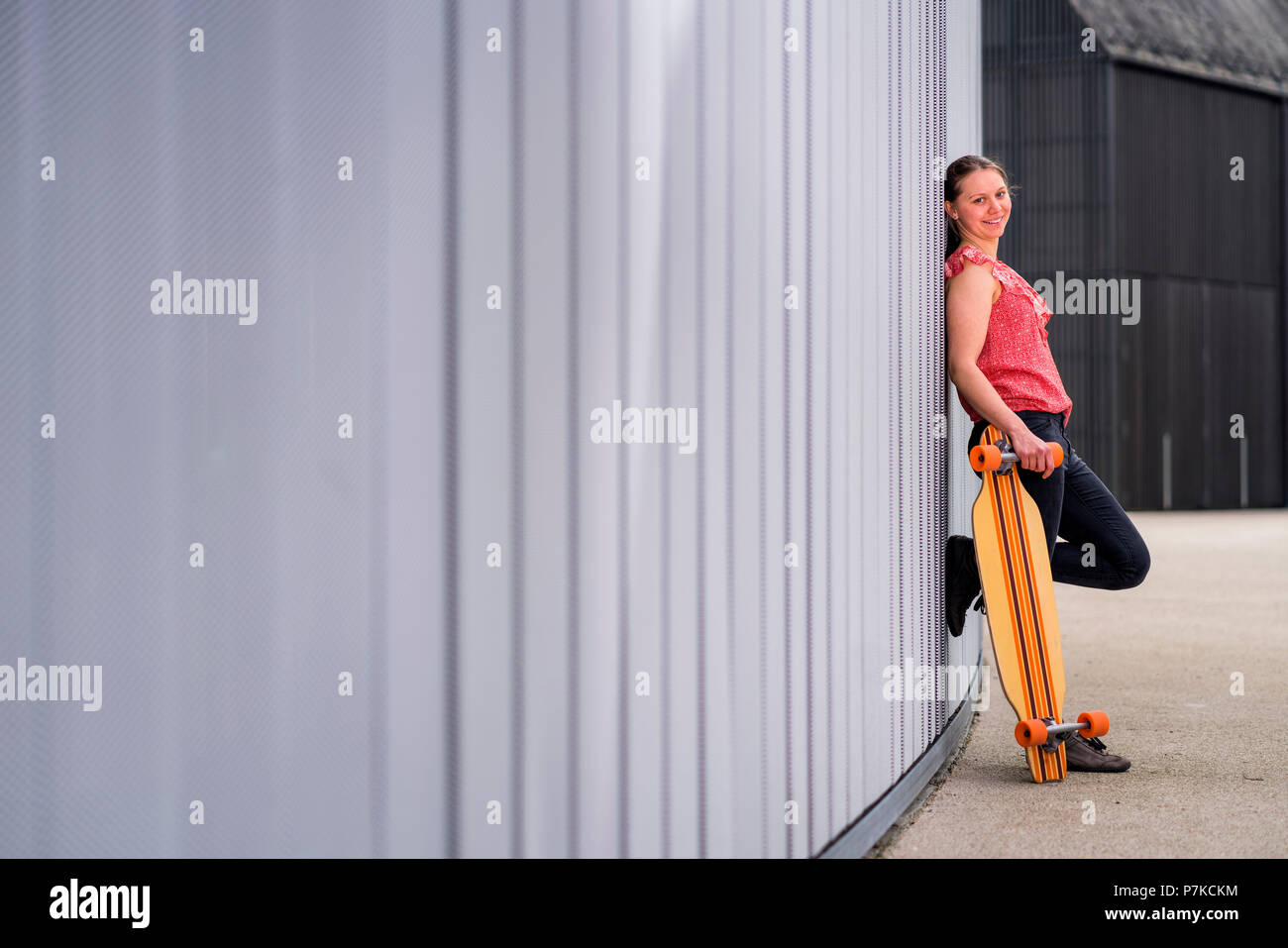 Woman with longboard, 23 years old, urban environment Stock Photo