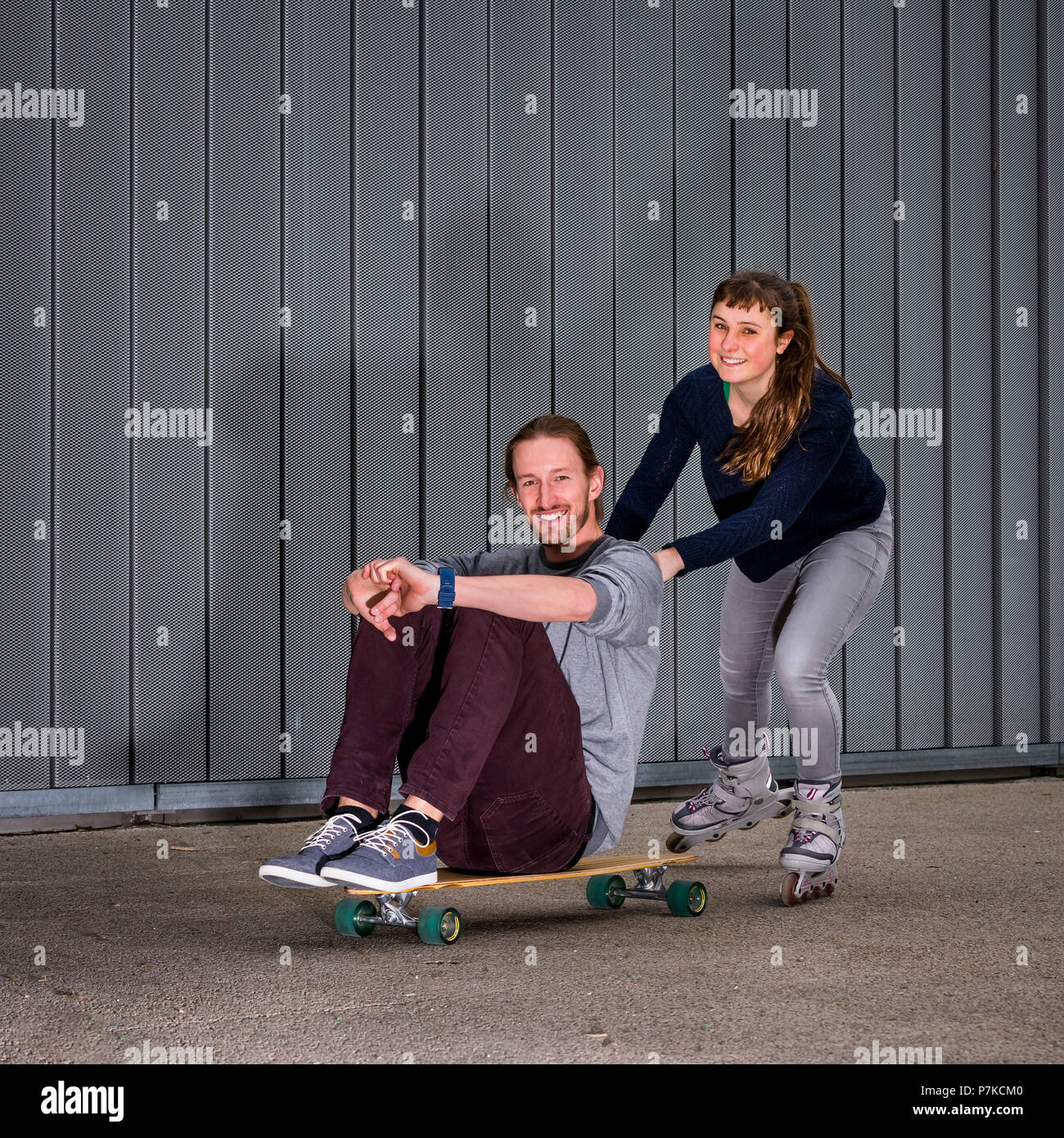 Man with longboard, 28 years old, teenager with inline skates, female, urban environment Stock Photo