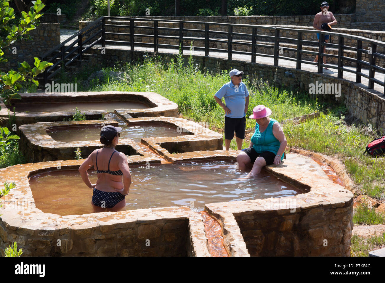 Larissa, Greece. 6th July, 2018. Tourists take a bath in curative red water at Kokkino Nero Village of Larissa in northeast Thessaly, Greece, July 6, 2018. Curative red water attracts visitors from all over the world looking for bath therapy along with mineral water drinking therapy. Credit: Apostolos Domalis/Xinhua/Alamy Live News Stock Photo