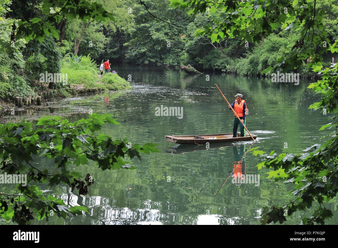 Guiyang, China's Guizhou Province. 5th July, 2018. A worker collects wastes at the Aha Lake wetland park in Guiyang, capital of southwest China's Guizhou Province, July 5, 2018. Guiyang has been improving its city park system in recent years and aims to provide a good living environment for its residents. Credit: Ou Dongqu/Xinhua/Alamy Live News Stock Photo