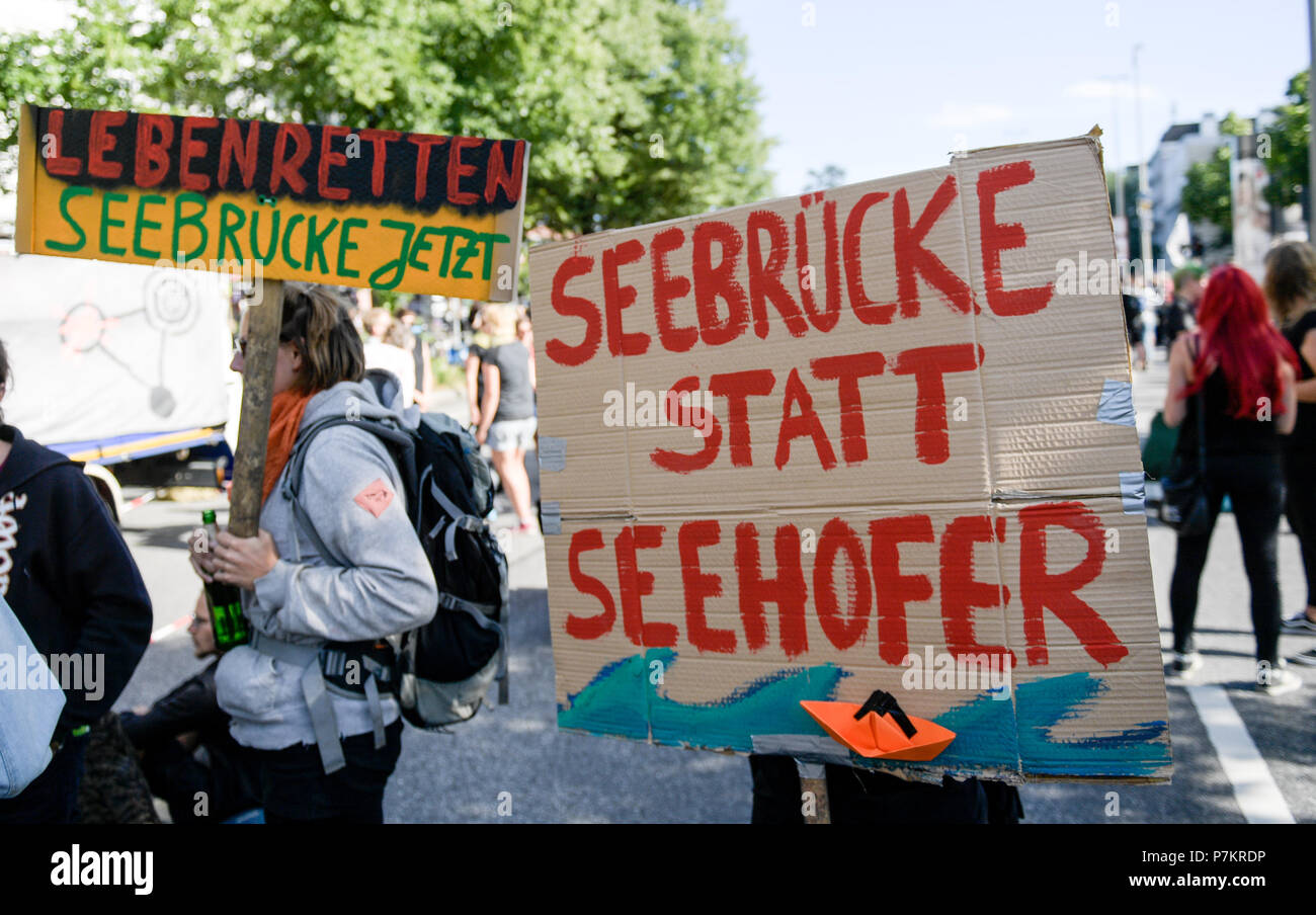Hamburg, Germany. 07th July, 2018. Protesters take to the streets one year after the G20 summit, carrying a sign reading 'Seebruecke statt Seehofer' (lit. 'Sea Bridge instead of Seehofer'). The demonstration runs under the slogan 'Solidarity without borders instead of G20'. Credit: Markus Scholz, Axel Heimken/dpa/Alamy Live News Stock Photo