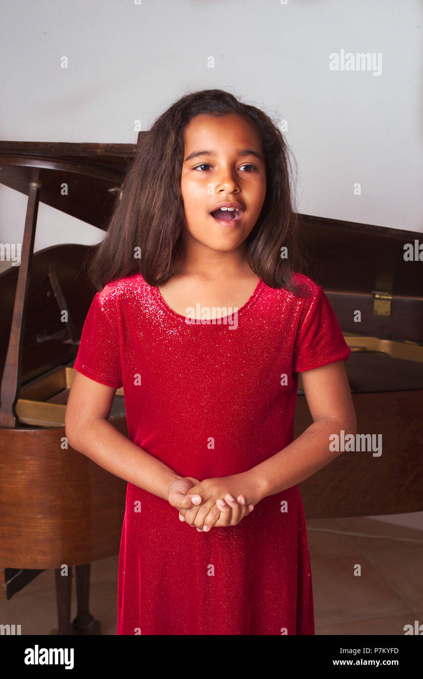 Young African American girl singing at her recital. MR © Myrleen Pearson.   Ferguson Cate Stock Photo