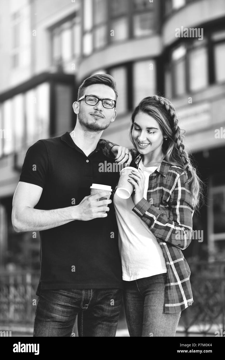 Portrait of happy couple walk on the street with coffee. Stock Photo