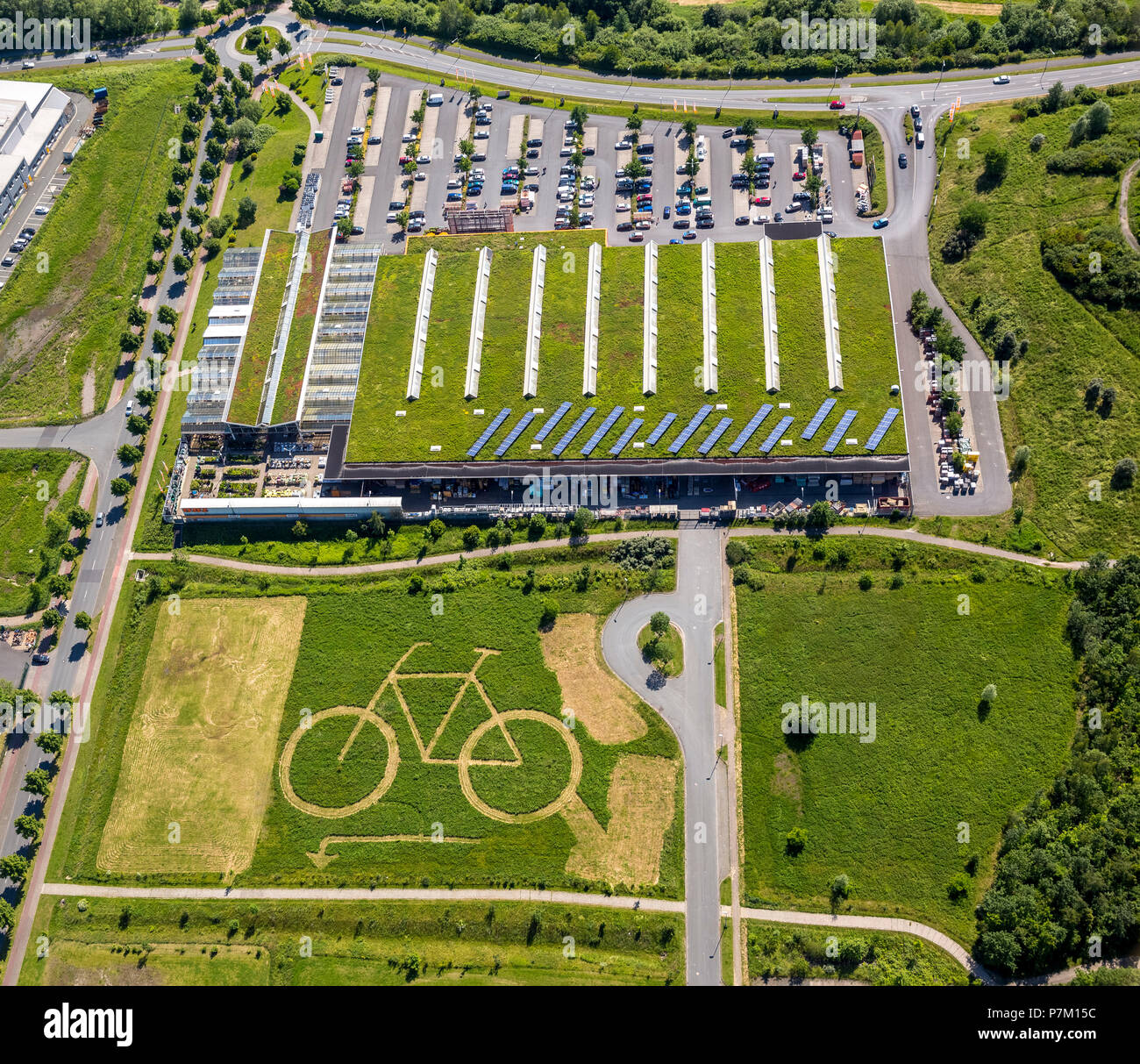 Hamm Ökozentrum with a large bike mowed out of the field behind OBI, lawn art and advertising for a bike shop, Hamm, Ruhr area, North Rhine-Westphalia, Germany Stock Photo