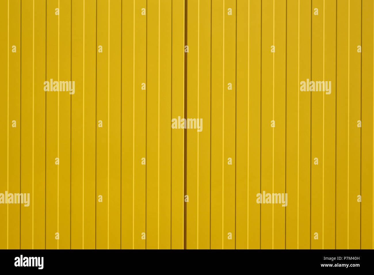 Close-up of a color intensive and bright yellow corrugated iron wall of a shopping mall. Stock Photo