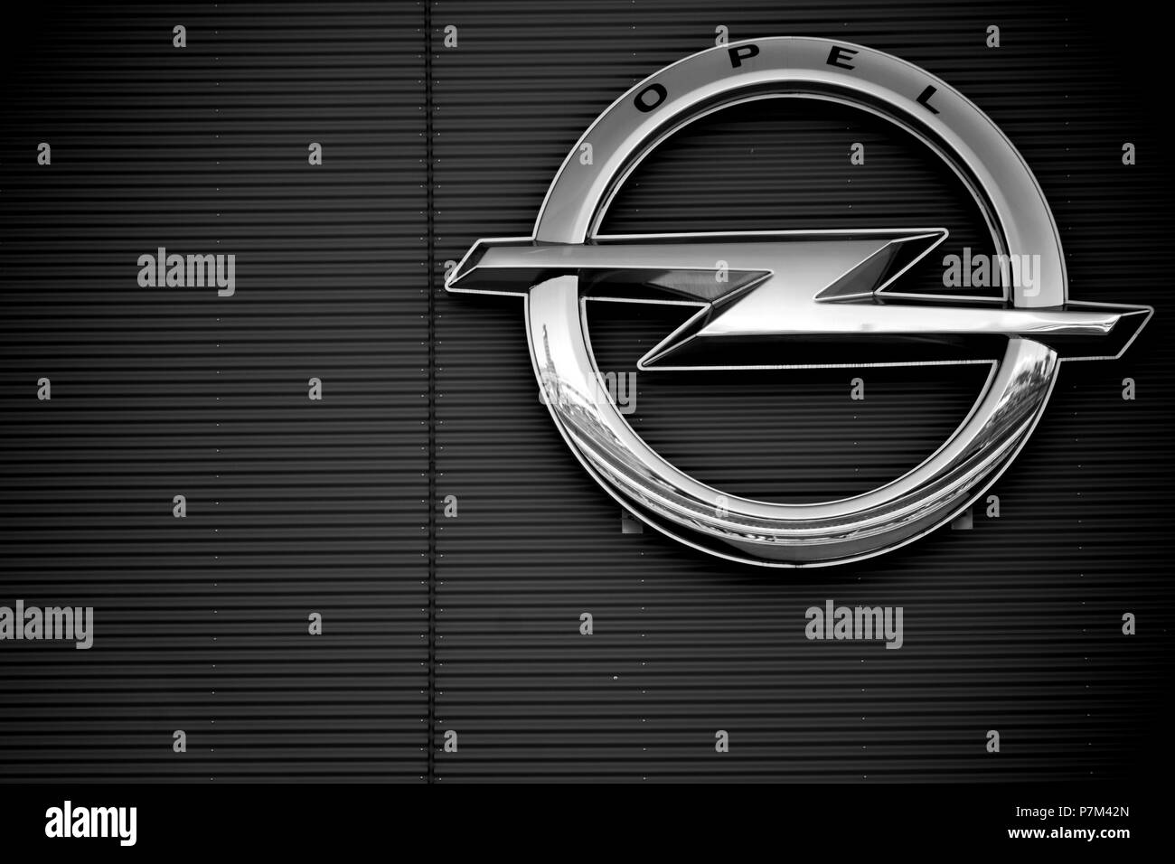 The symbol and shiny logo of the Opel company on the facade of an industrial building of Opelwerke in Rüsselsheim. Stock Photo