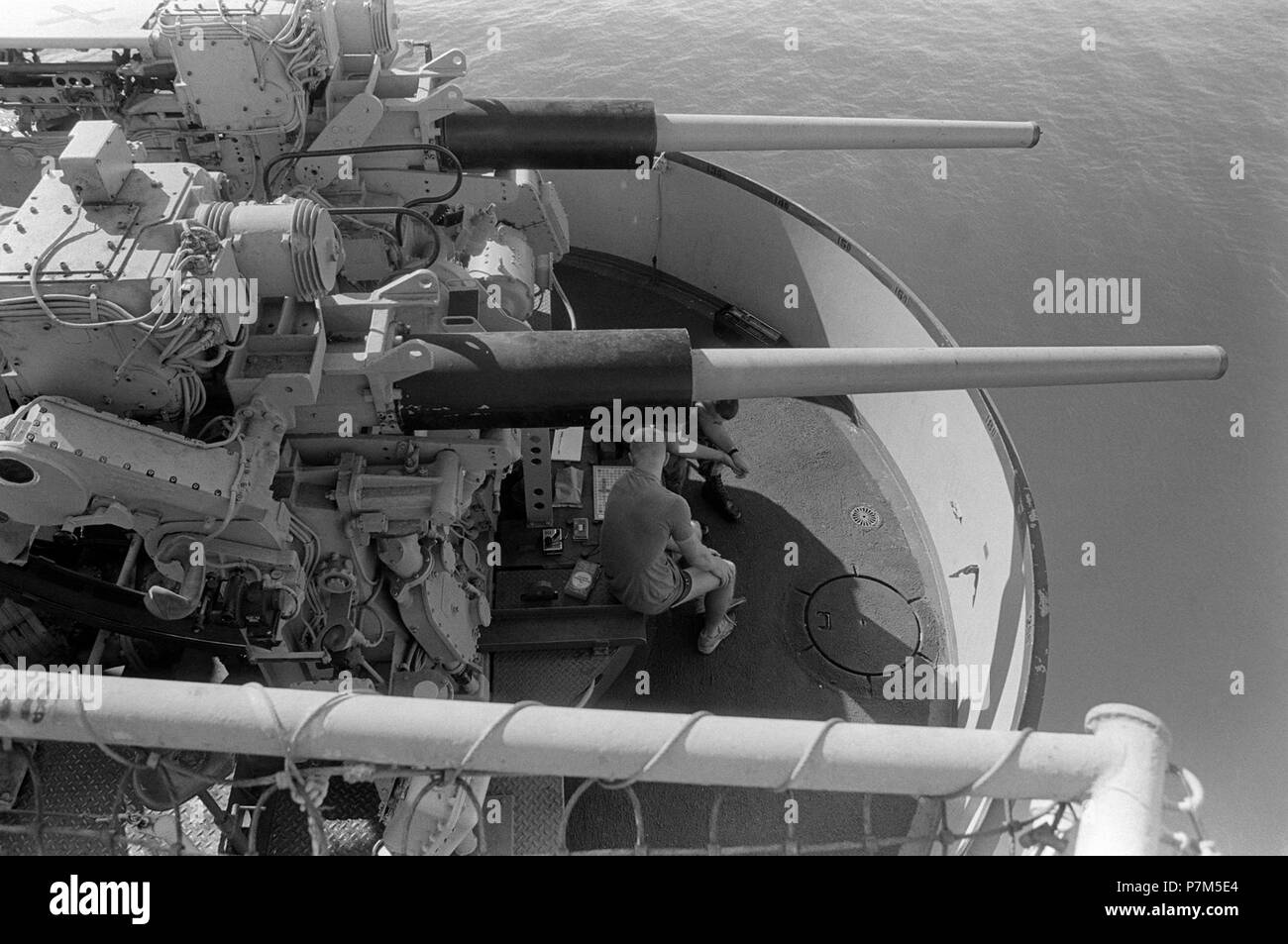 3 inch guns aboard USS Okinawa (LPH-3), 1987. Marines aboard the amphibious assault ship USS OKINAWA (LPH 3) play Scrabble under the aft Mark 33 3-inch/50-caliber gun mount as the ship cruises the gulf. Stock Photo