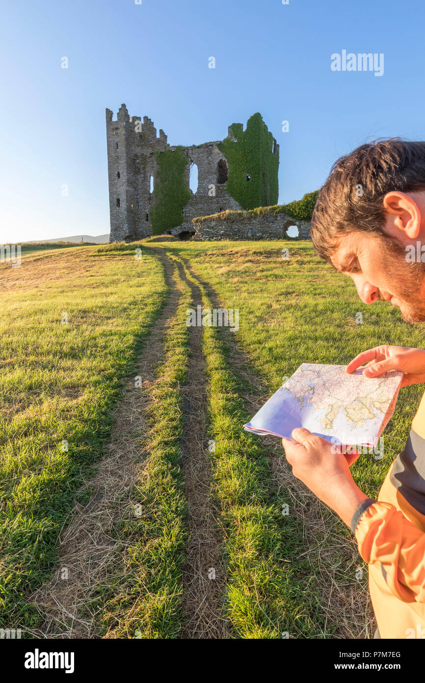 Hiker with map, Ballycarbery Castle, Cahersiveen, County Kerry, Ireland Stock Photo