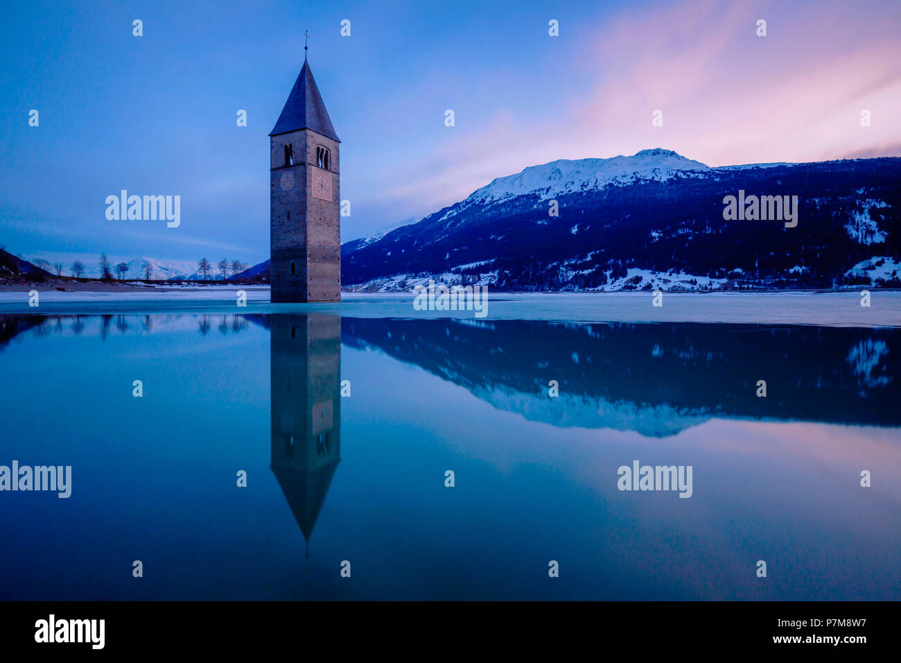 The bell-tower of Graun in Vinschgau at dusk, Reschensee - Lago di Resia, Bolzano, South Tyrol, Trentino Alto Adige, Italy Stock Photo