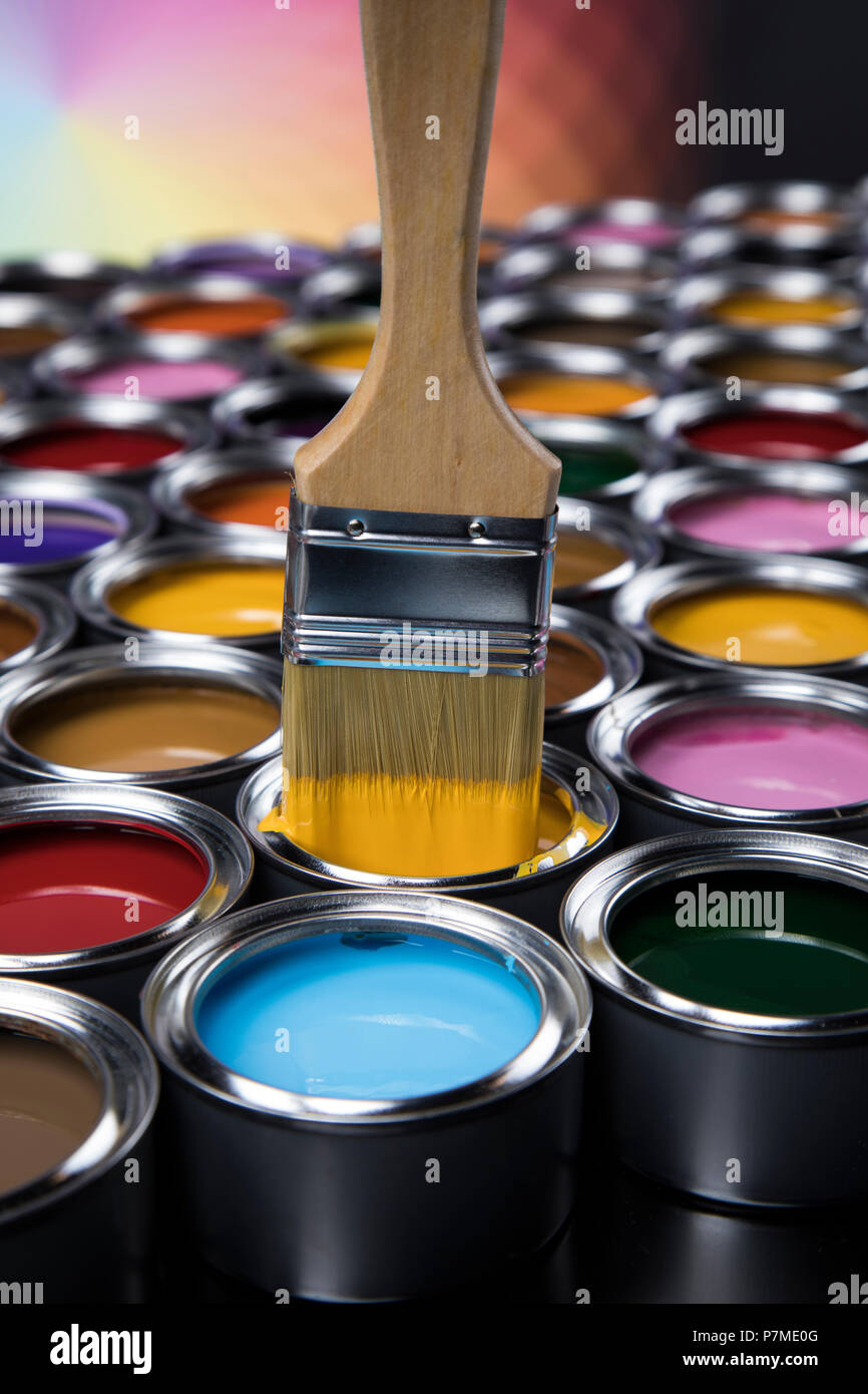 Tin cans with paint, brushes and bright palette of colors Stock Photo