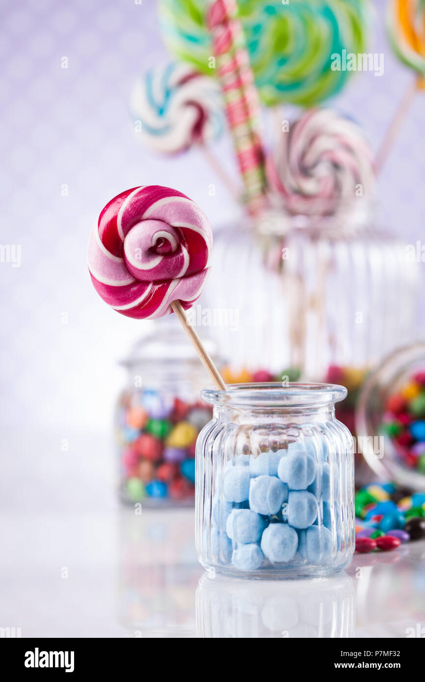 Colorful lollipops and different colored round candy and gum balls ...