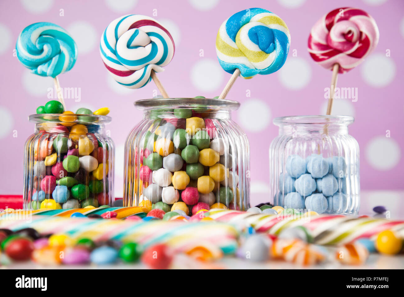 Colorful lollipops and different colored round candy and gum balls ...