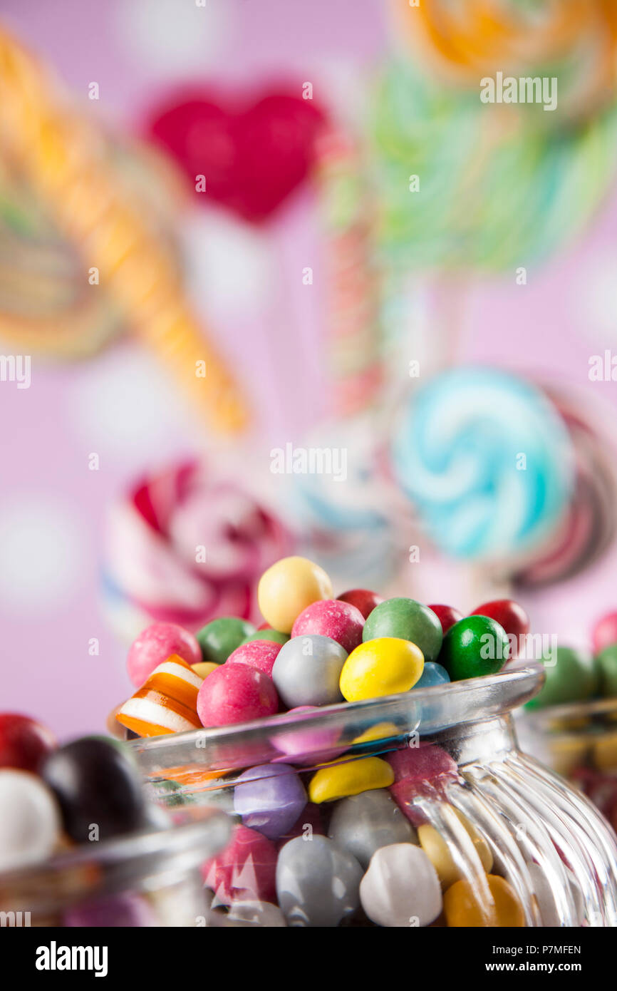 Colorful lollipops and different colored round candy and gum balls ...