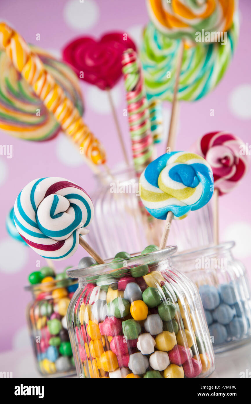 Colorful lollipops and different colored round candy and gum balls ...