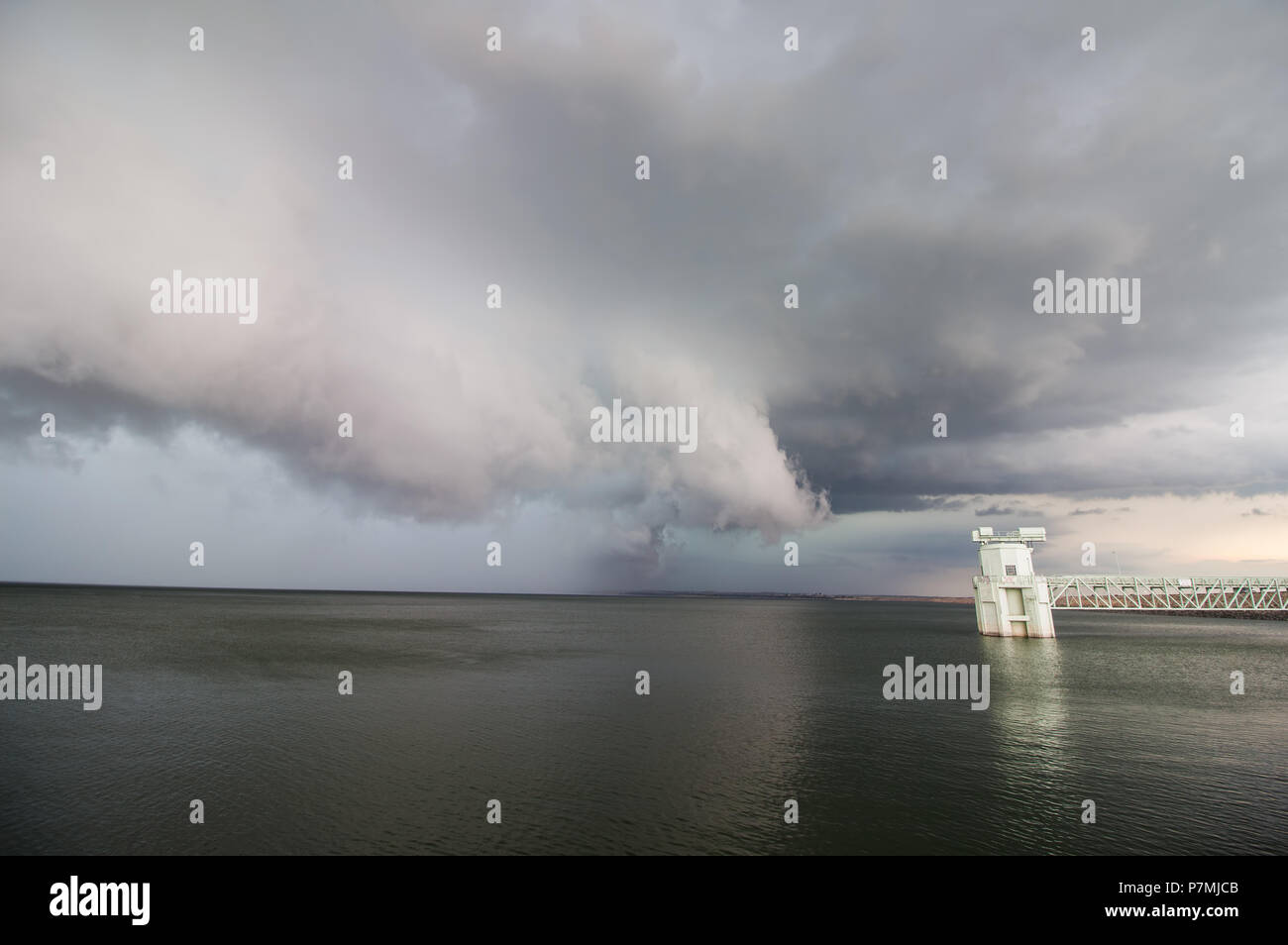 A severe storm and shelf cloud rapidly approach over a lake. Stock Photo