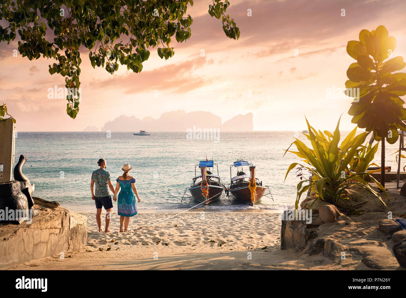 Happy couple on the tropical beach of Phi Phi island at sunset in Southern Thailand. Travel magazine concept. Stock Photo