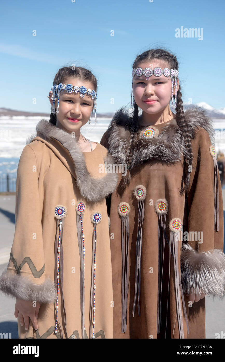 Two Chukchi girls in folk dresses against spring Arctic landscape Stock Photo