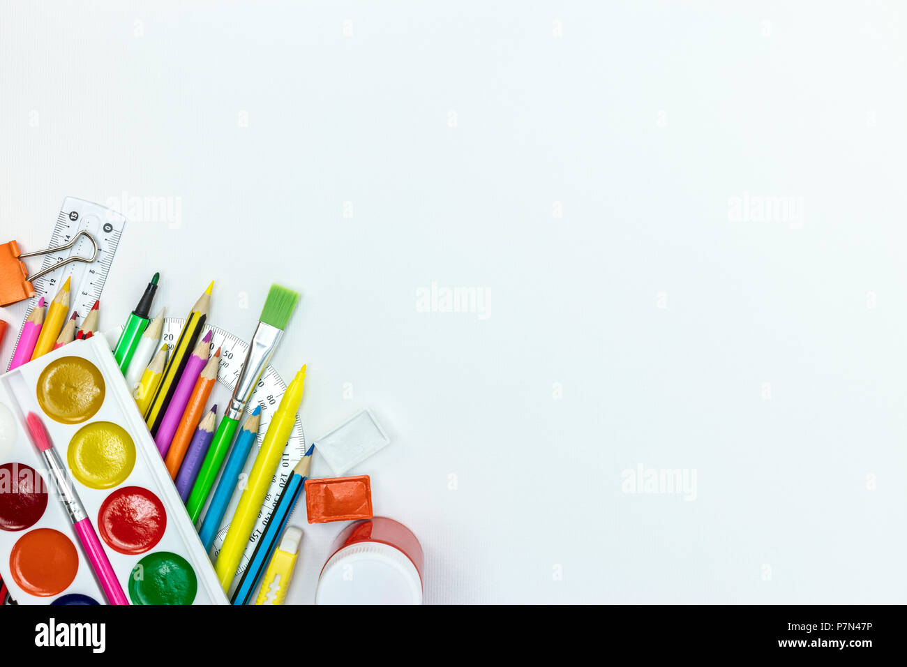 bright school supplies and accessories for kids on white desk surface background, flat lay Stock Photo