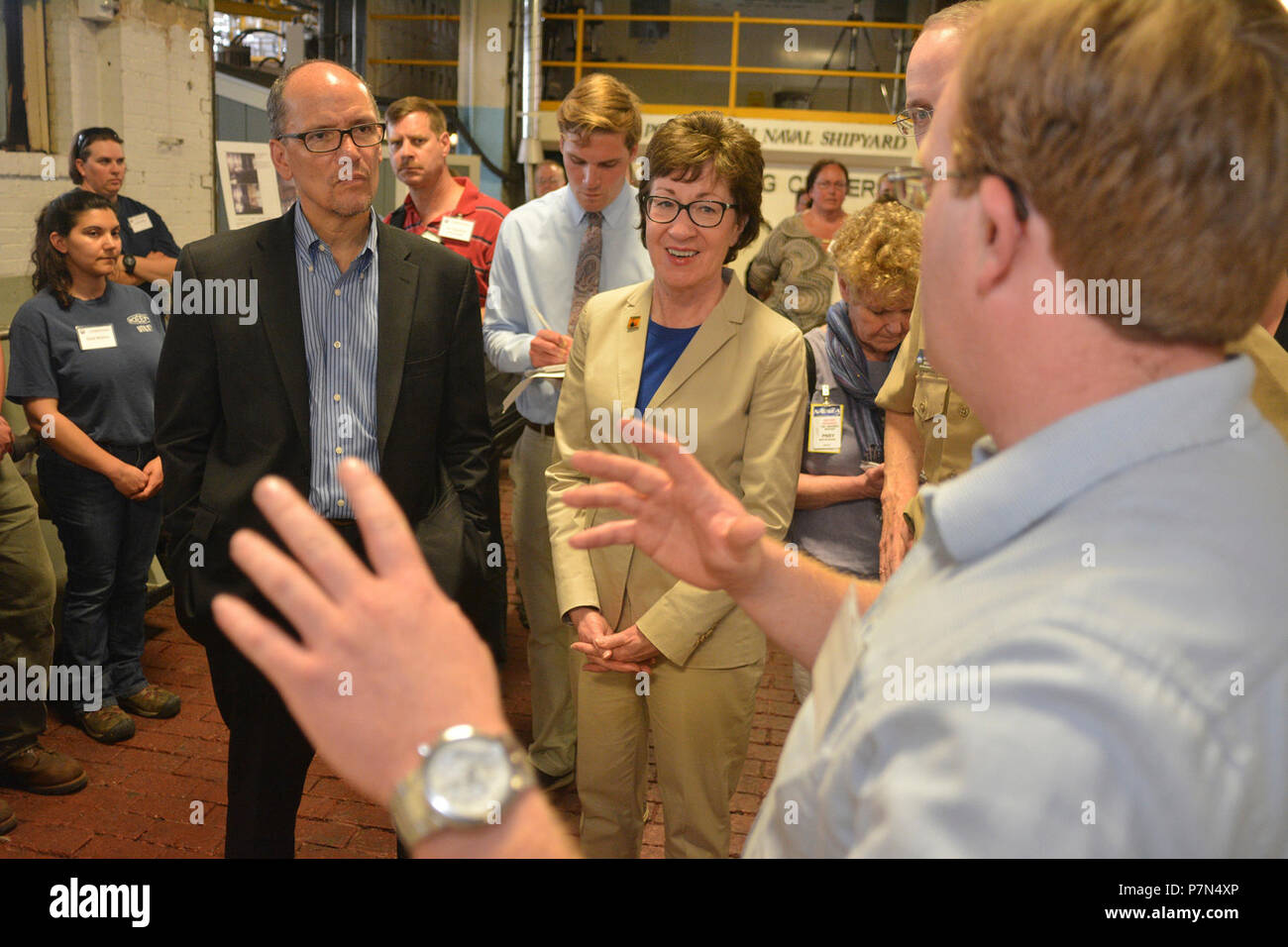 KITTERY, Maine -- 5/27/15 -- U.S. Secretary of Labor, Thomas Perez  and U.S. Senator Susan Collins (R-Maine)  listen to Portsmouth Naval Shipyard (PNS) employee Brent Maxwell describing his part of the apprentice program at PNS in Kittery on Wednesday.  The delegation visited Bath Iron Works in Bath and Portsmouth Naval Shipyard in Kittery to promote private and public partnerships supporting apprenticeships in the maritime industry. Stock Photo