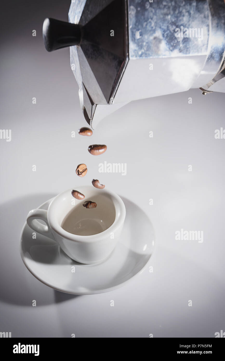Coffee pot pouring roasted coffee beans into the cup Stock Photo Alamy