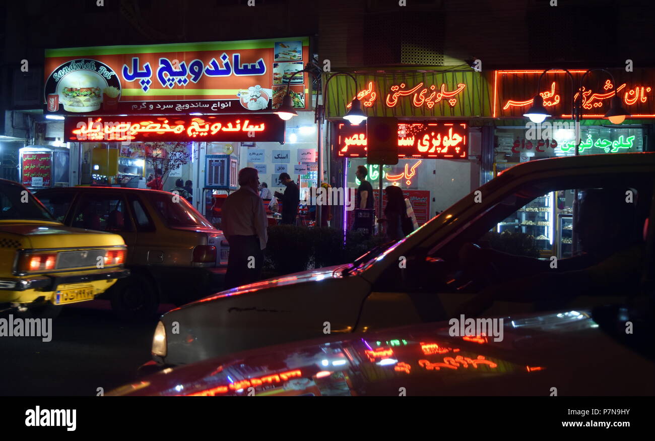 Nightlife in Iran: boulevard of crowded restaurants lit up in LED and fluorescent lights - Qazvin, Iran Stock Photo