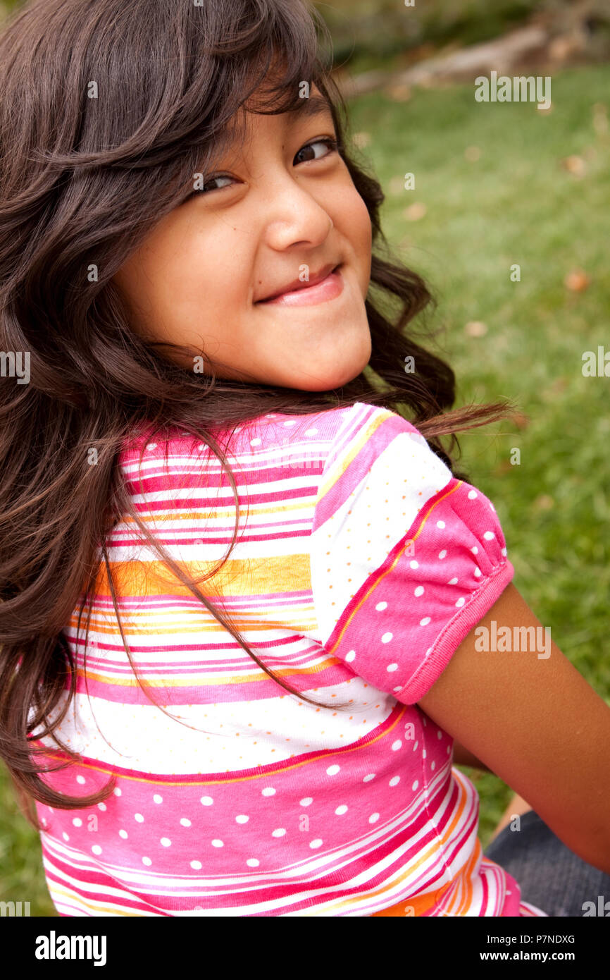 Portrait of a cute little girl smiling outside. Stock Photo