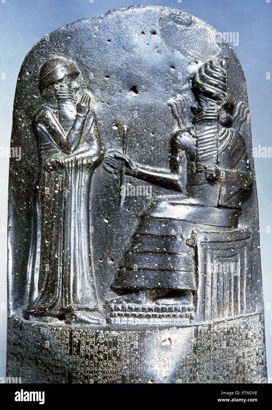 Law Code of Hammurabi, king of Babylon. Basalt. 18th century BC. Detail relief: Hammurabi (standing) depicted as receiving his royal insignia from Shamash, god of justice. Louvre Mueum. Paris, France. Stock Photo