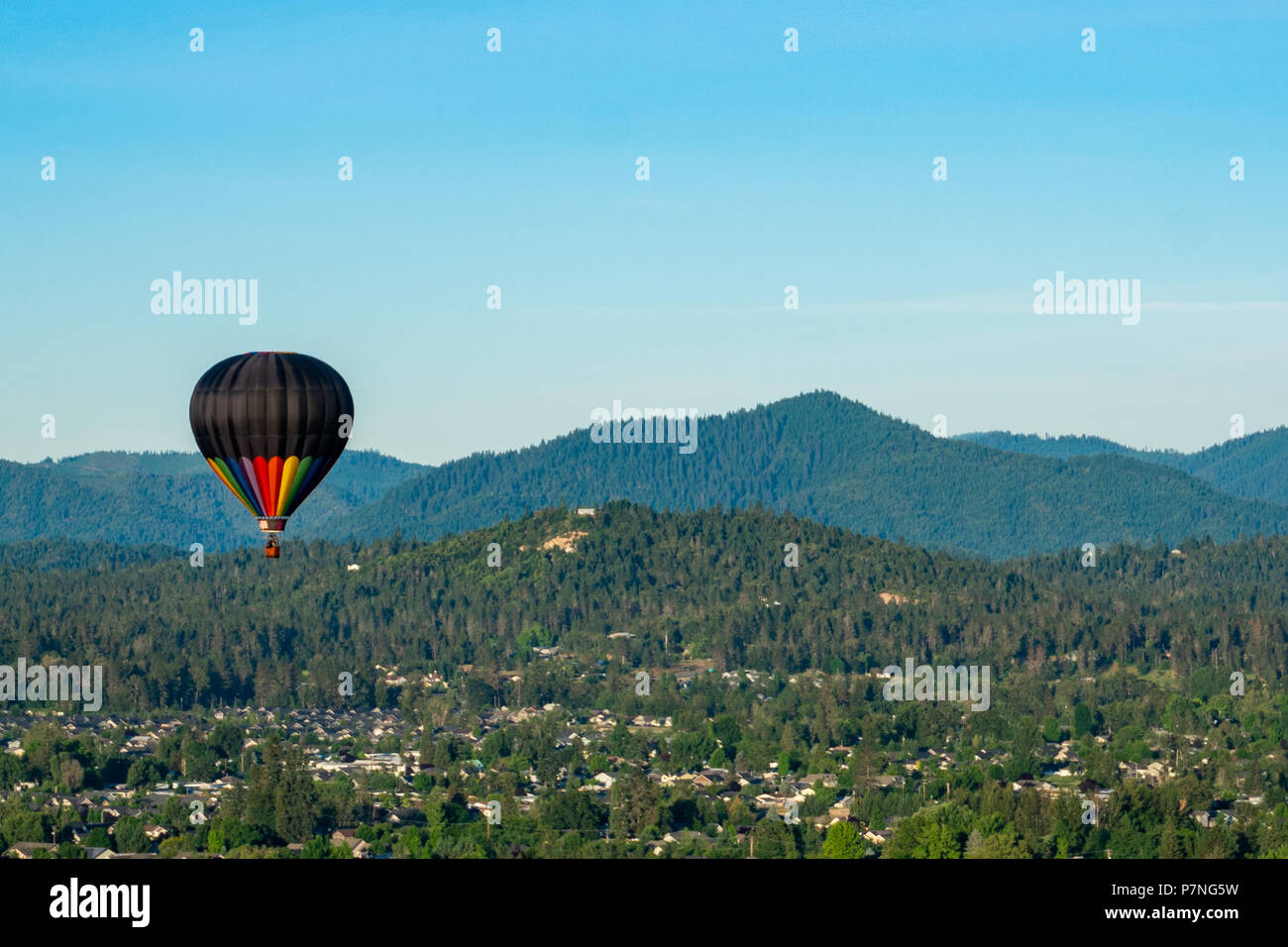 Hot air balloons soaring over fields and mountains during the Balloon