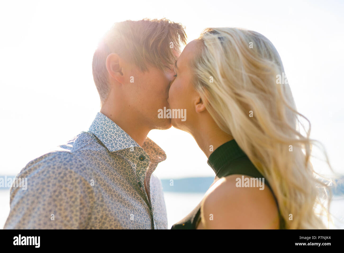 Kissing couple in romantic embrace on beach at summer Stock Photo